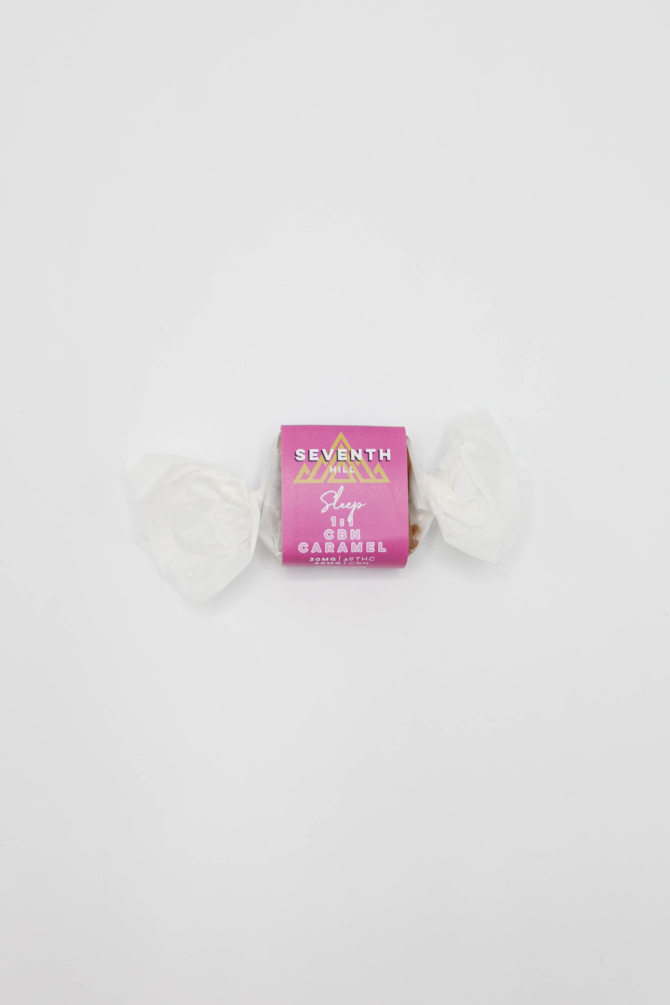 A small wrapped candy gift item centered on a plain white background. The center wrapper is bright pink with gold and white text reading 'SEVENTH HILL' and '1:1 CBN Sleep Caramel'.