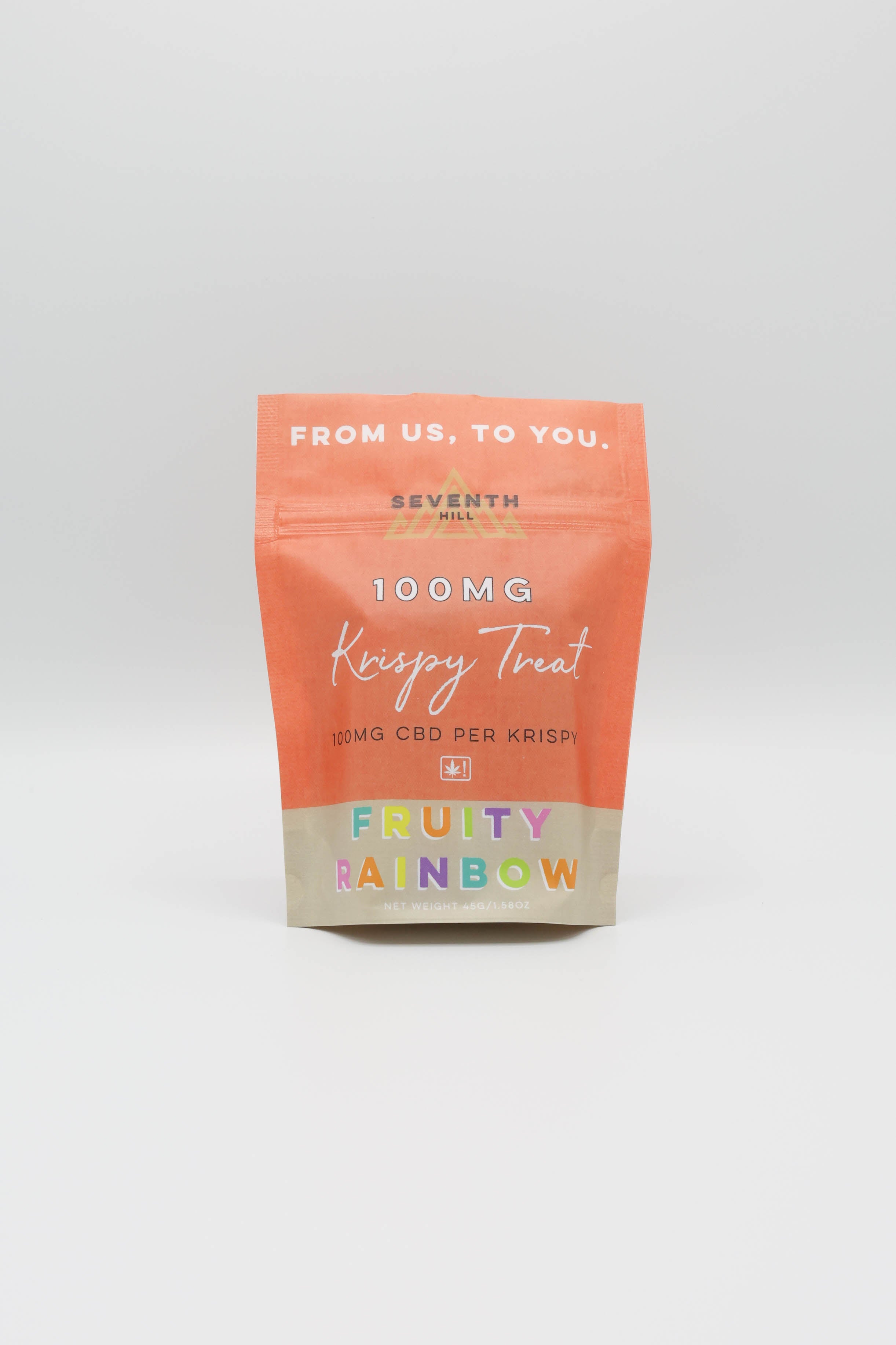 A stand-up pouch of Seventh Hill 'Krispy Treat' 100mg CBD, featuring a red-orange top half and a beige bottom half with 'FRUITY RAINBOW' printed in multicolored letters, set against a light gray background.