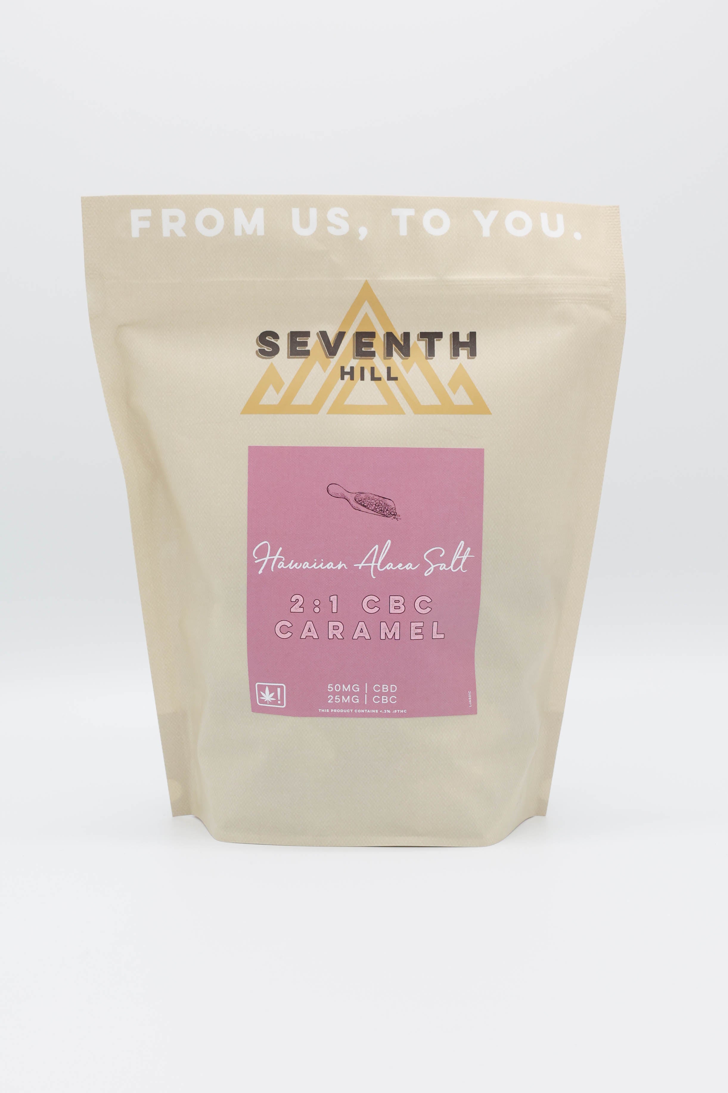A stand-up pouch of Seventh Hill Hawaiian Alaea Salt Caramels, featuring a beige package with a pink label and gold logo on a white background.
