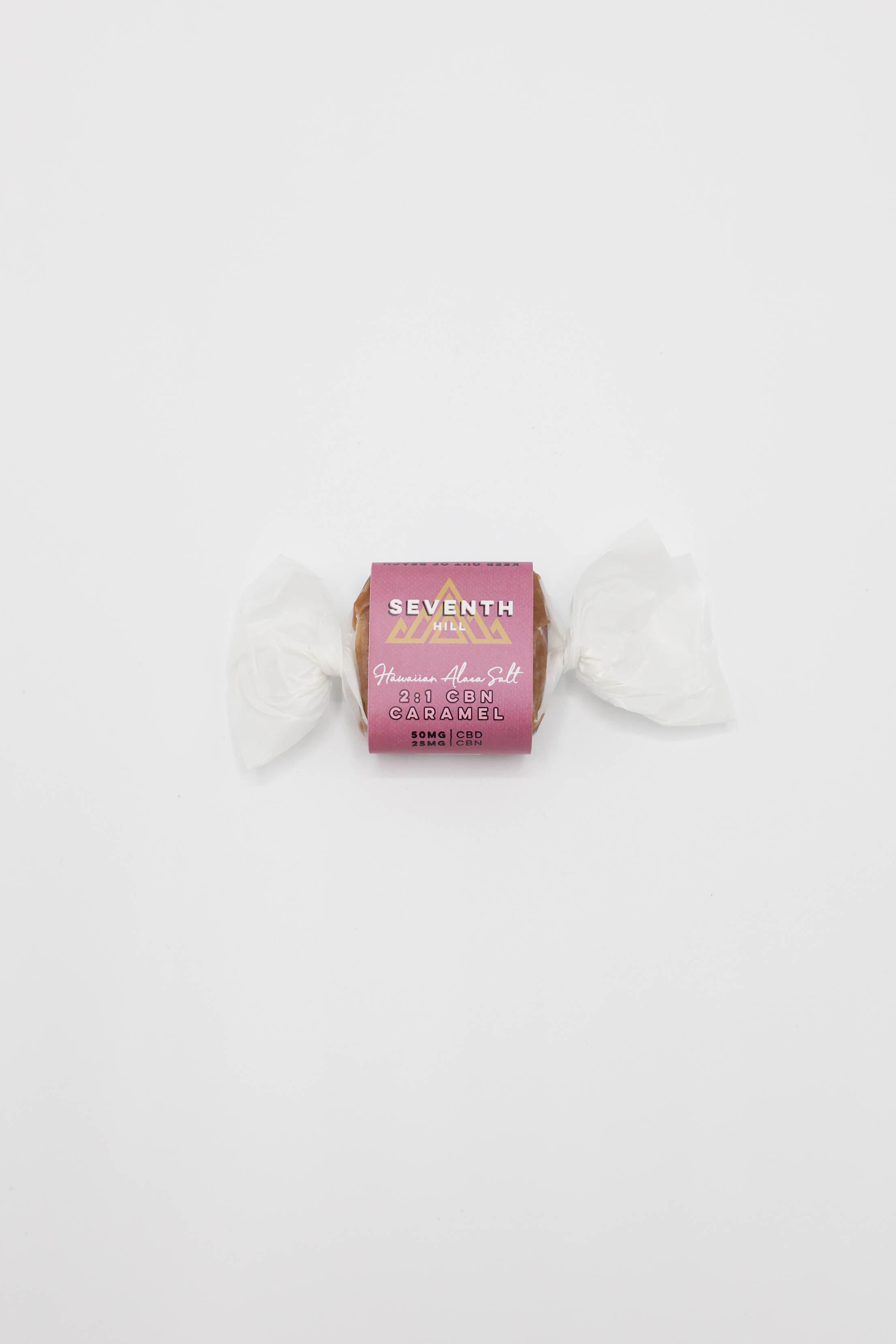 A single wrapped candy with a pink label reading 'SEVENTH HILL' and '2:1 CBN Caramel' on a plain white background.