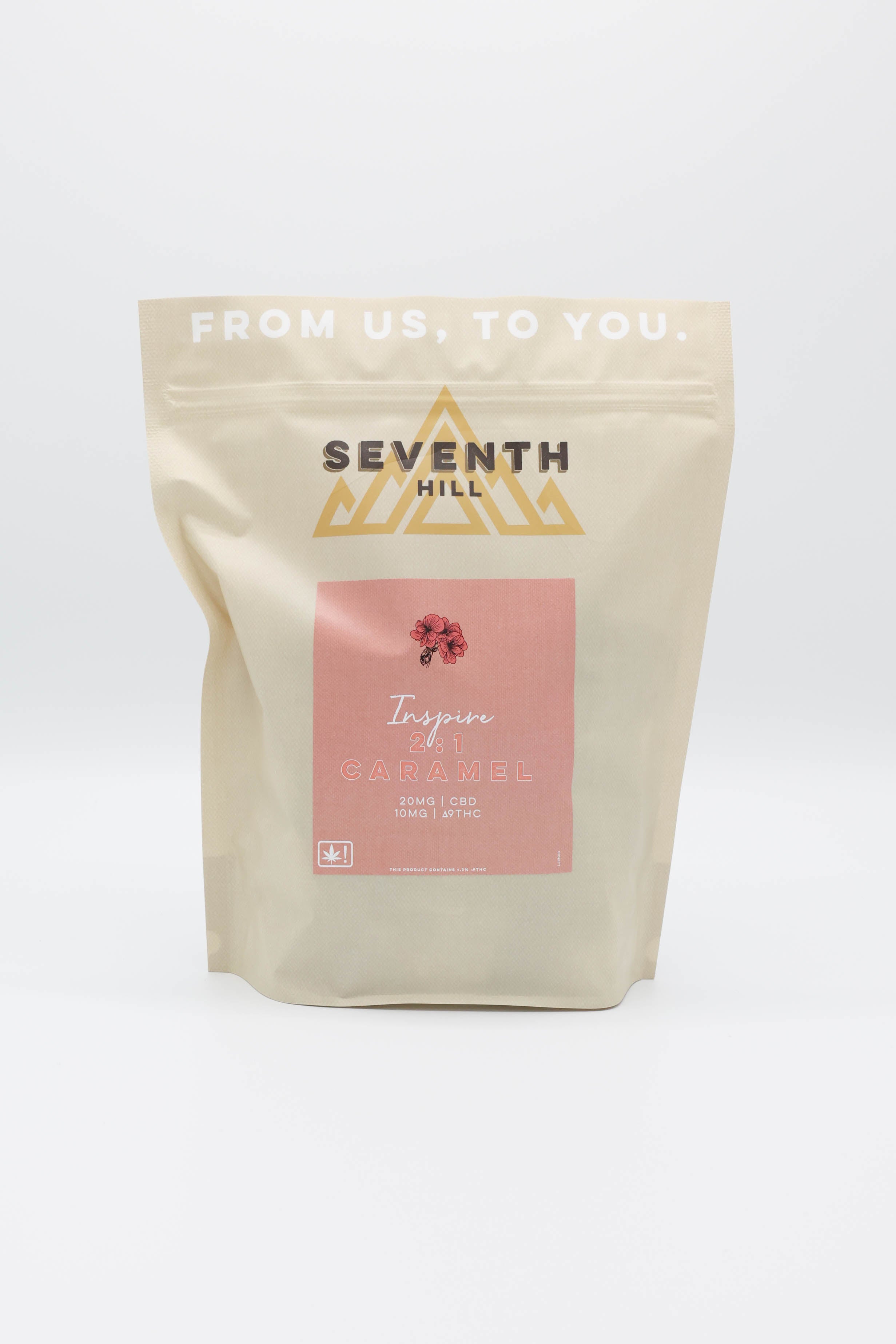 A stand-up pouch of Seventh Hill Caramels in the '2:1 Inspire' flavor, featuring a cream-colored bag with a gold logo and a pink label on a white background.