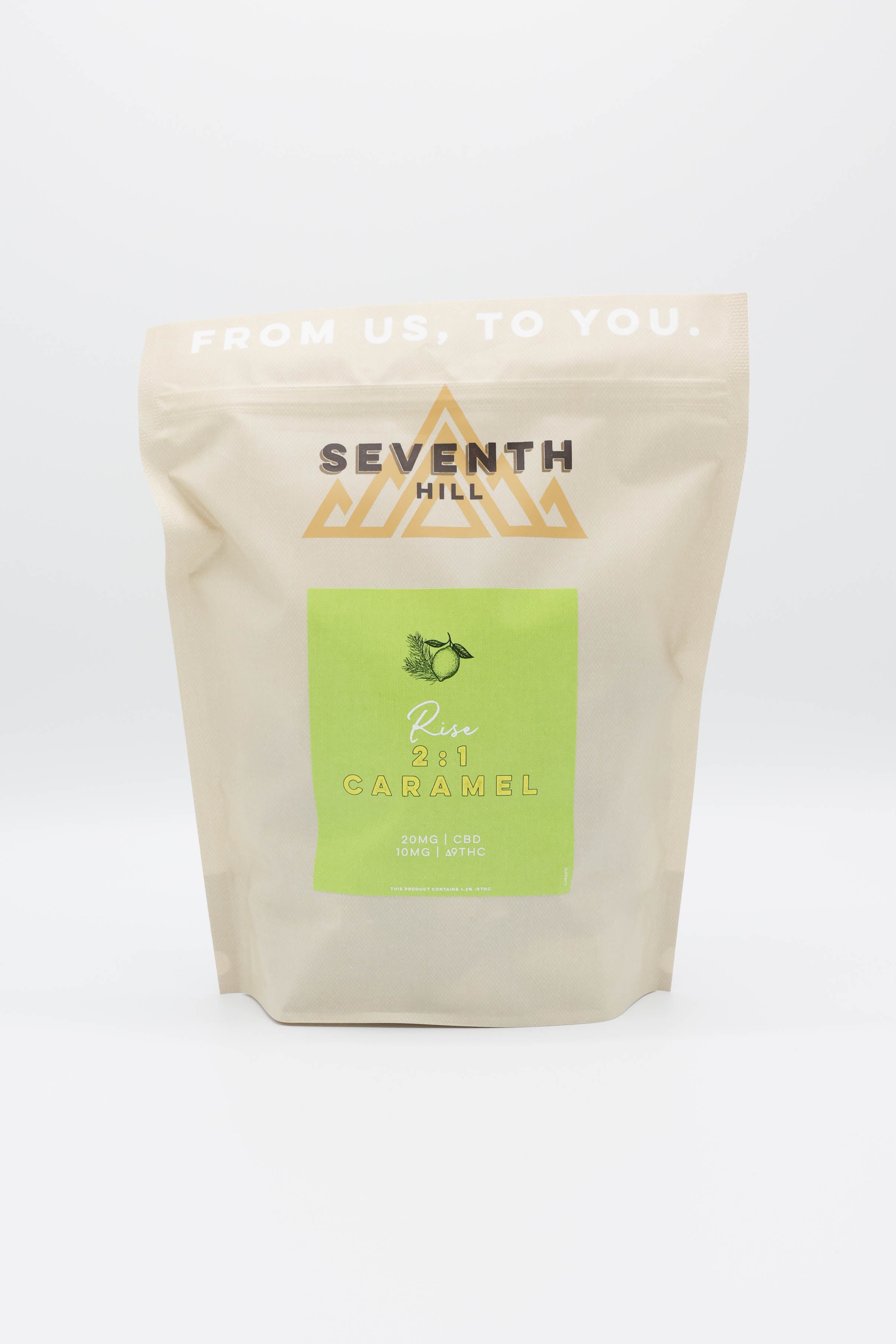 A stand-up pouch of Seventh Hill 2:1 Rise Caramels on a clean white background. The pouch is a light cream color with a prominent lime green label in the center and gold geometric logo details.