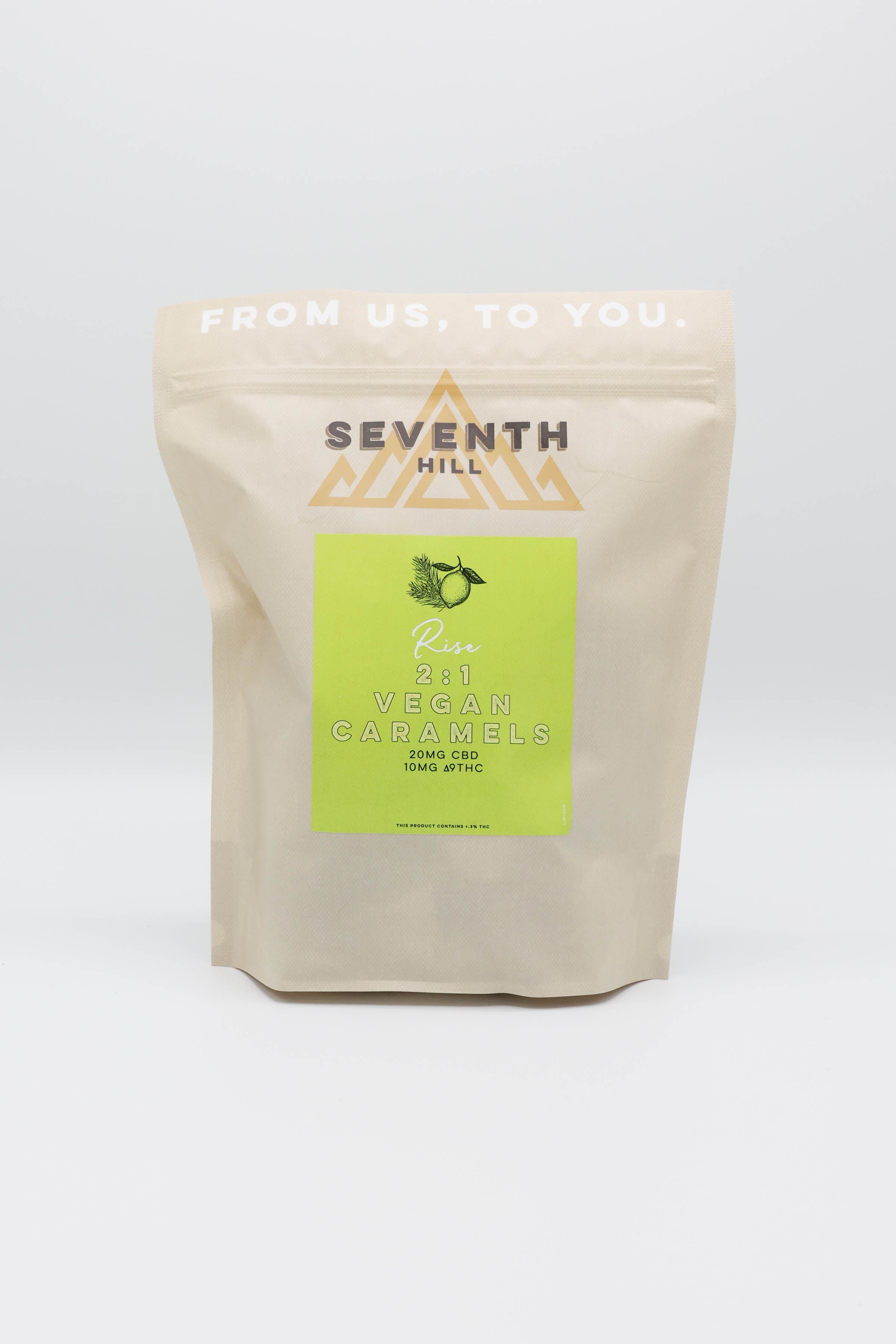 A stand-up pouch of Seventh Hill 2:1 Vegan Caramels on a white background. The pouch is a natural beige color with a bright lime green label in the center that reads 'SEVENTH HILL' and 'Vegan Caramels'.