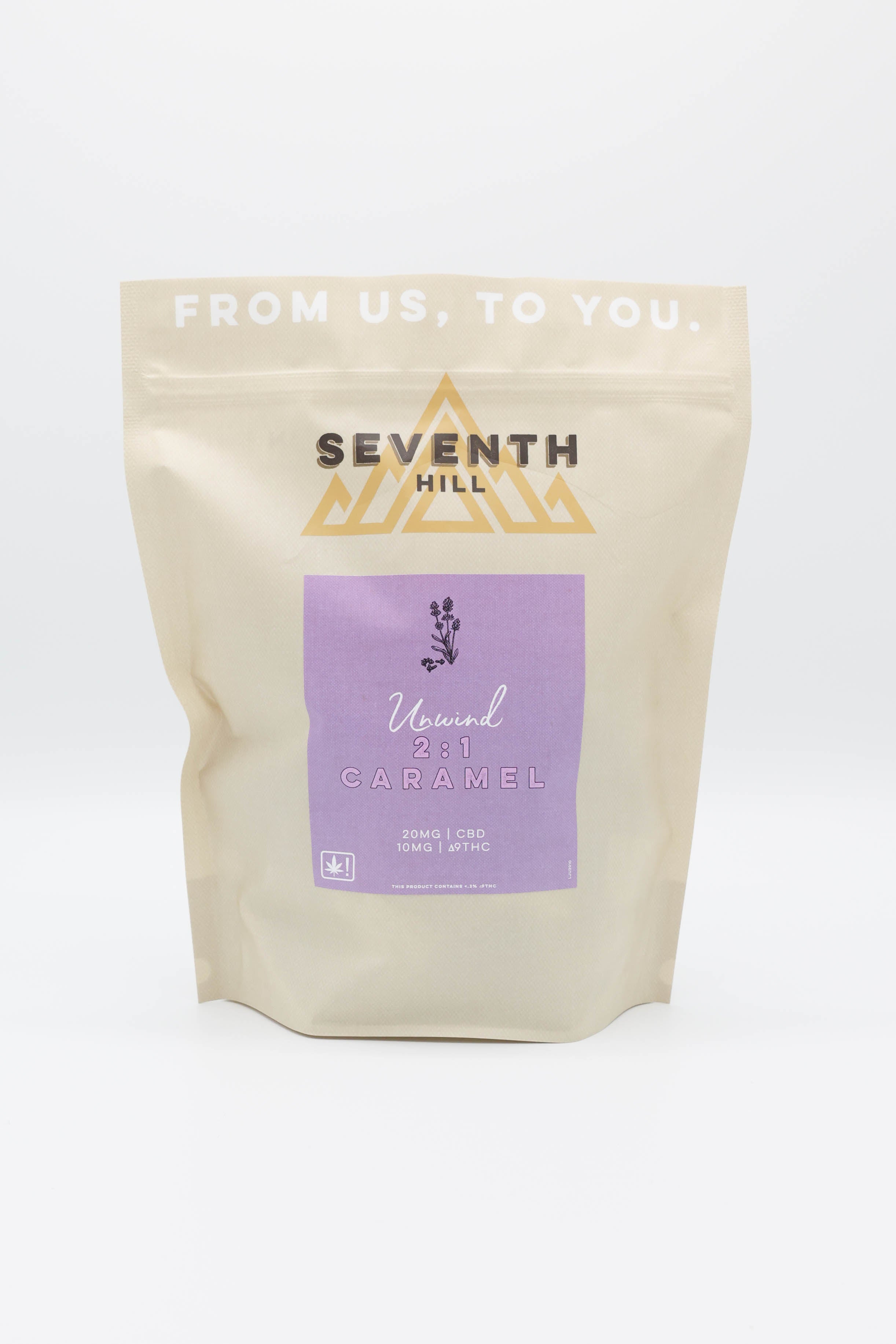 A stand-up pouch of Seventh Hill 2:1 Unwind Caramels on a clean white background. The pouch is a warm cream color with a lavender purple label in the center and gold brand lettering.