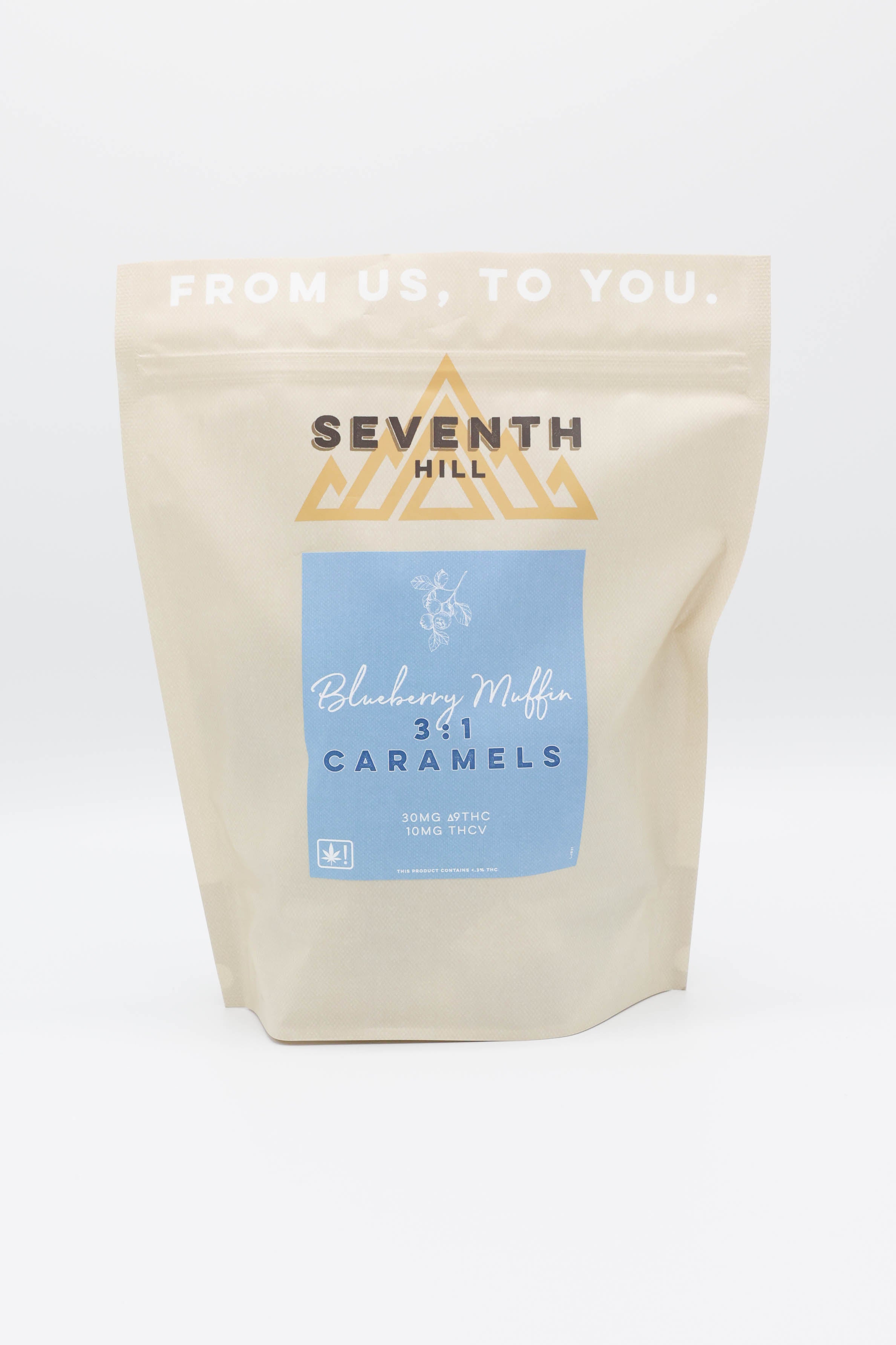 A stand-up pouch of Seventh Hill Blueberry Muffin 3:1 Caramels on a clean white background. The packaging is a light beige matte material with a central light blue label and gold brand logo.