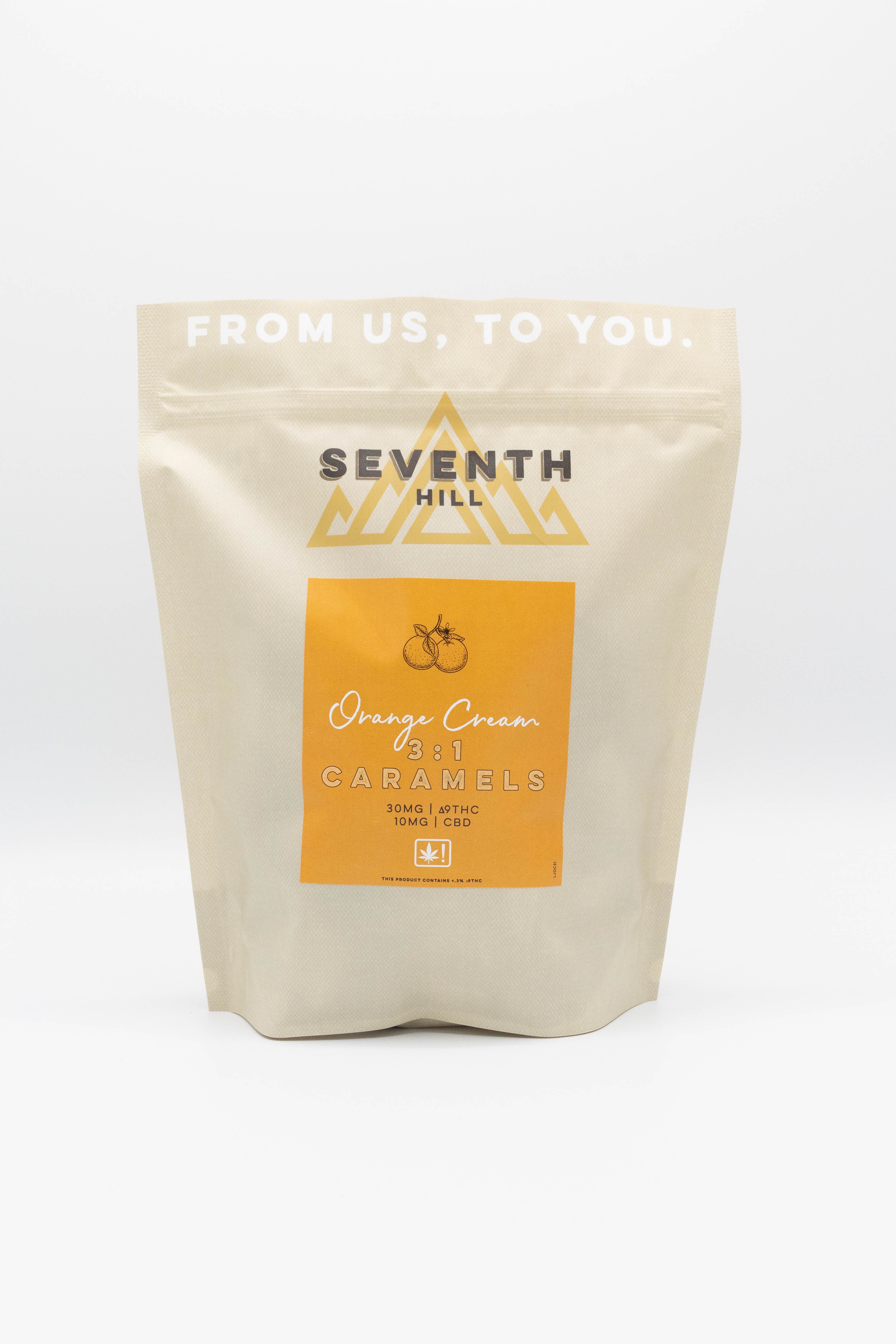A stand-up pouch of Seventh Hill 3:1 Orange Cream Caramels on a clean white background. The packaging is a light beige matte material with a prominent orange label in the center and white branding text.