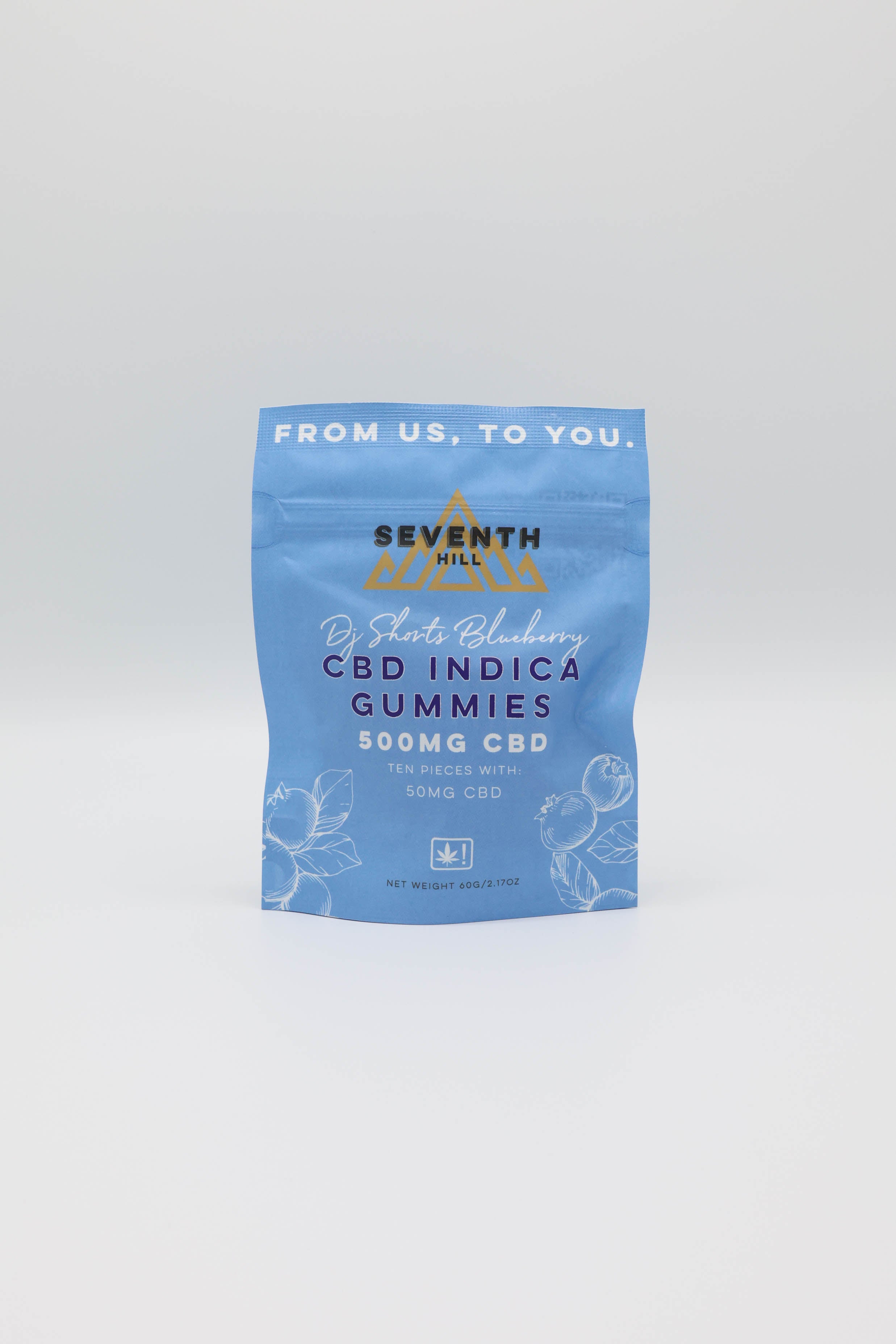 A light blue stand-up pouch of Seventh Hill CBD Indica Gummies, featuring a gold mountain logo and white text, set against a plain light gray background.