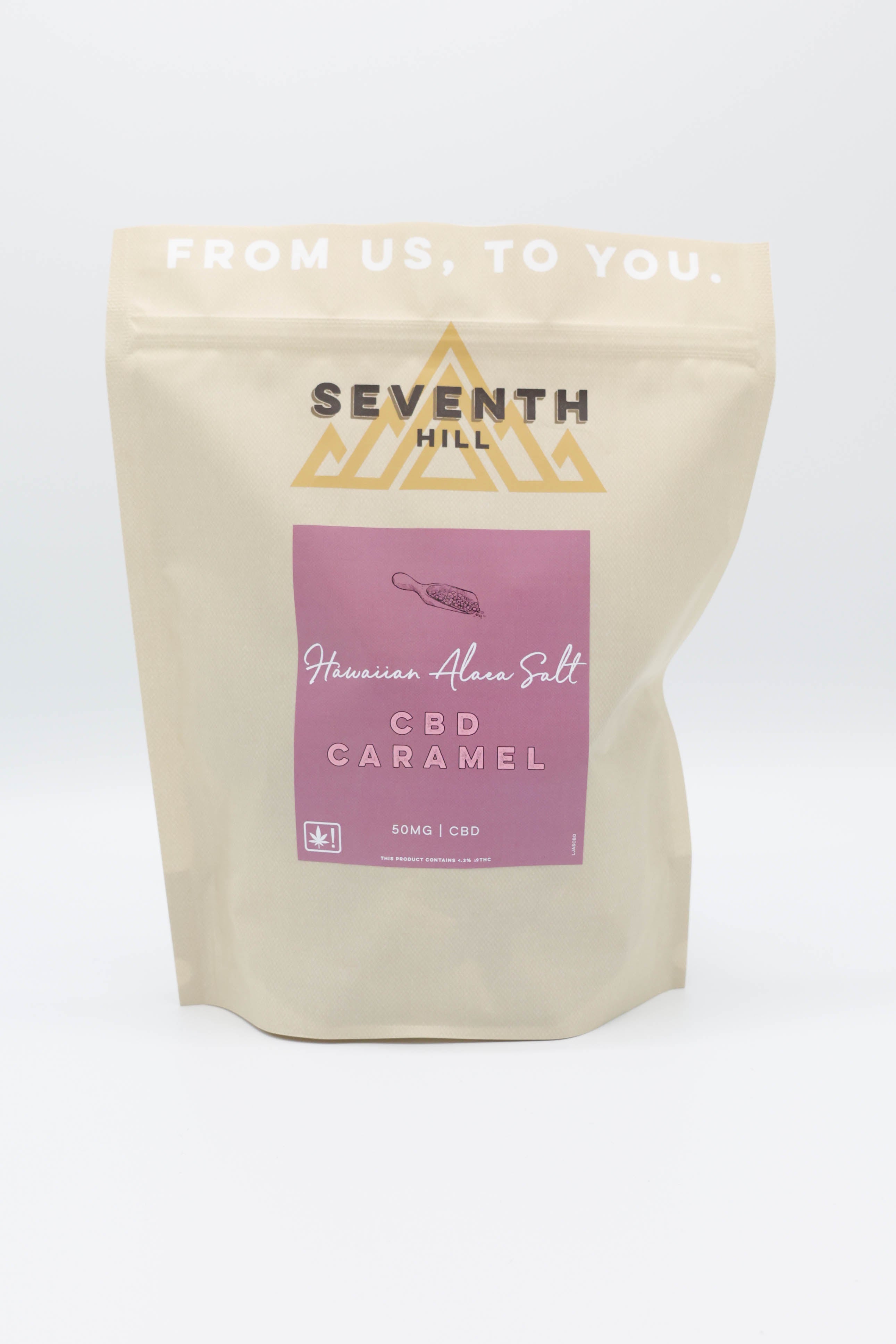 A stand-up pouch of Seventh Hill Hawaiian Alaea Salt CBD Caramel  on a clean white background. The pouch is a warm cream color with a prominent dusty pink label on the front featuring the product name in white text.