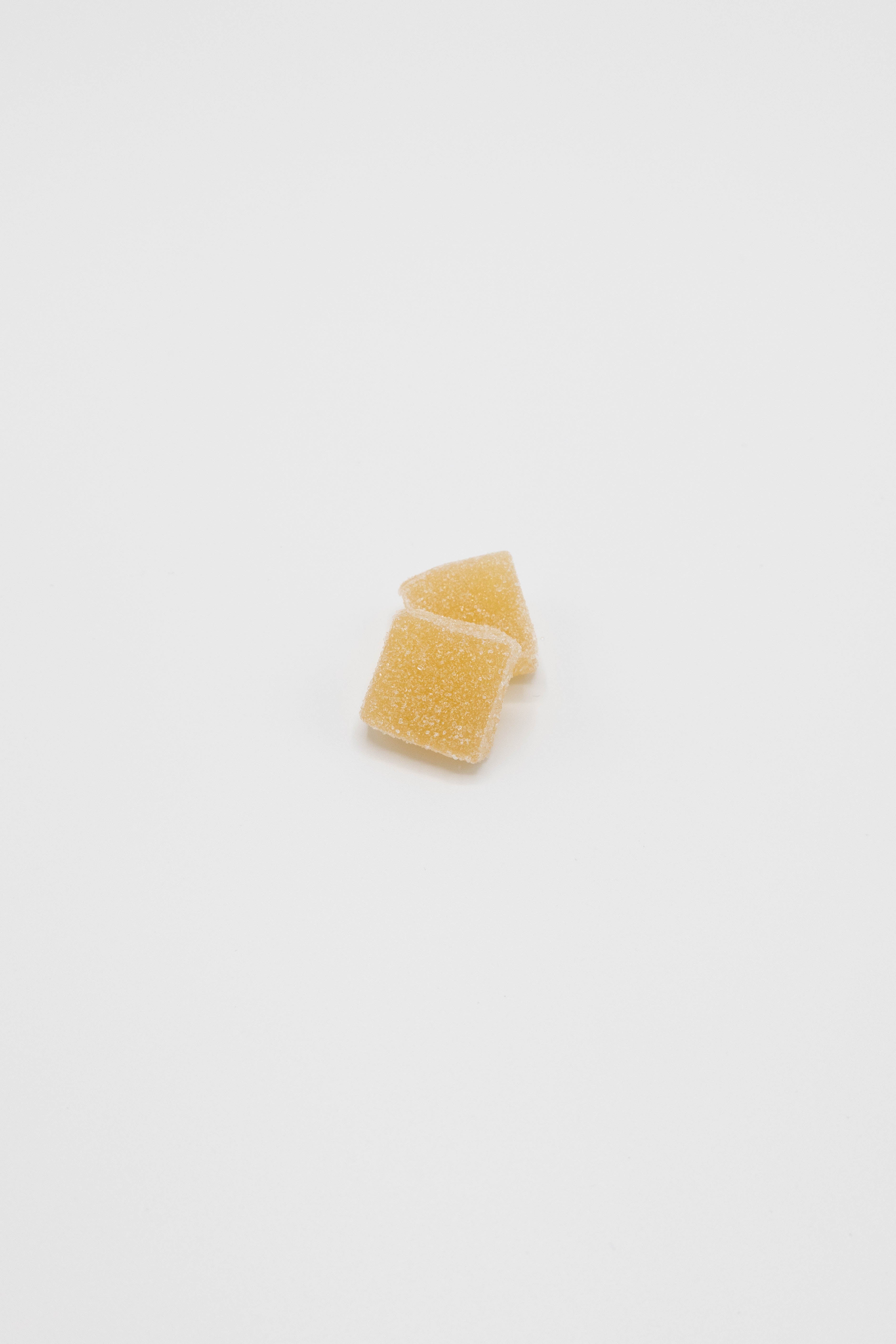 Two small, translucent yellow-orange square gel pads stacked slightly offset on a plain white background.
