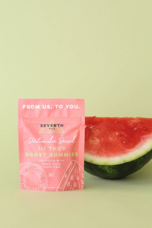 A bag of gummies sits with pieces of wood painted to look like watermelons